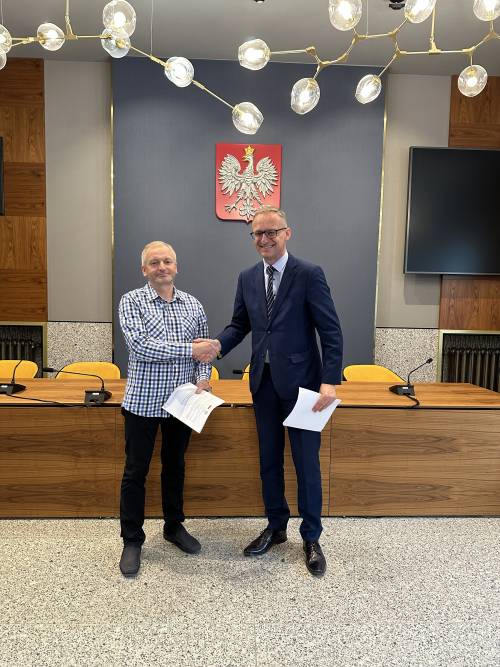 Burmistrz z wykonawcą inwestycji po podpisaniu umowy ściskają sobie dłonie