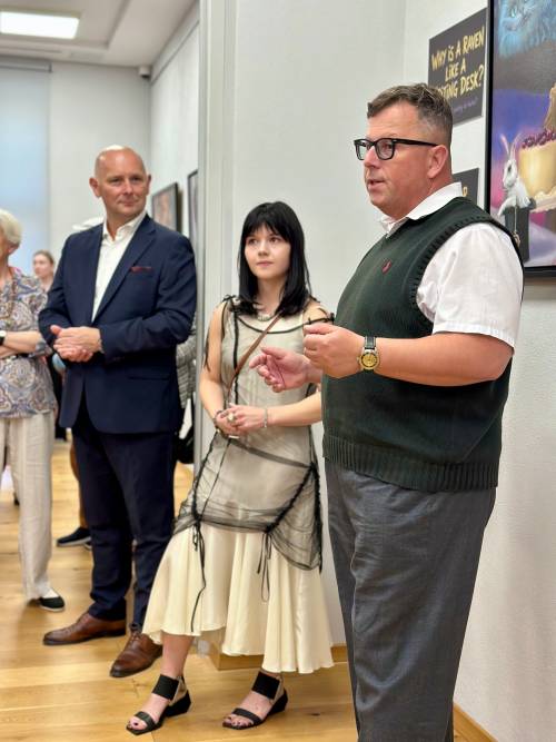Dwóch mężczyzn i kobieta stoją przy obrazach