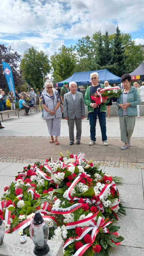Trzy starsze panie i pań idą z wiązanką kwiatów