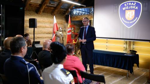 Burmistrz Pruszcza stoi przed grupą osób siedzących
