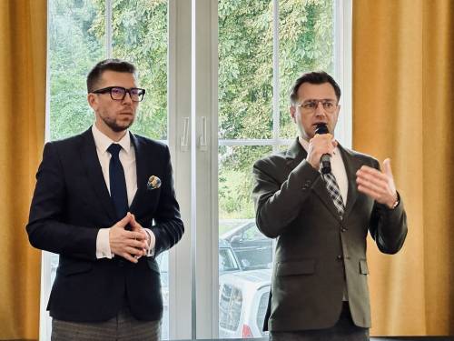 Zbliżenie na dwóch mężczyzn, jeden z nich trzyma w ręku mikrofon