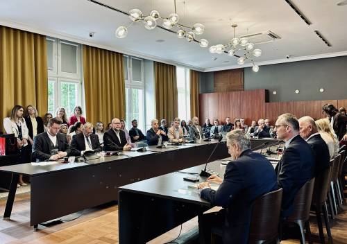 Widok na sale obrad i siedzących przy stołach radnych