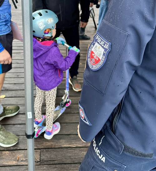 Zbliżenie na policjanta i dziewczynkę na hulajnodze